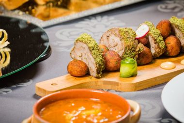 Close-up of a beautifully plated meat dish with various sides, perfect for a refined dining experience.